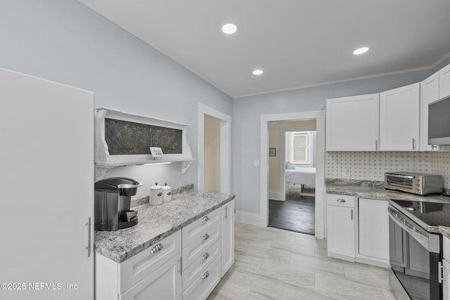 kitchen featuring backsplash, range with electric cooktop, light stone countertops, a toaster, and white cabinets