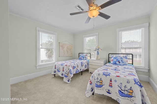 carpeted bedroom featuring visible vents, baseboards, ceiling fan, and crown molding