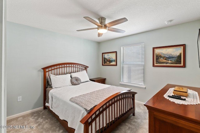 bedroom with ceiling fan, carpet floors, and a textured ceiling