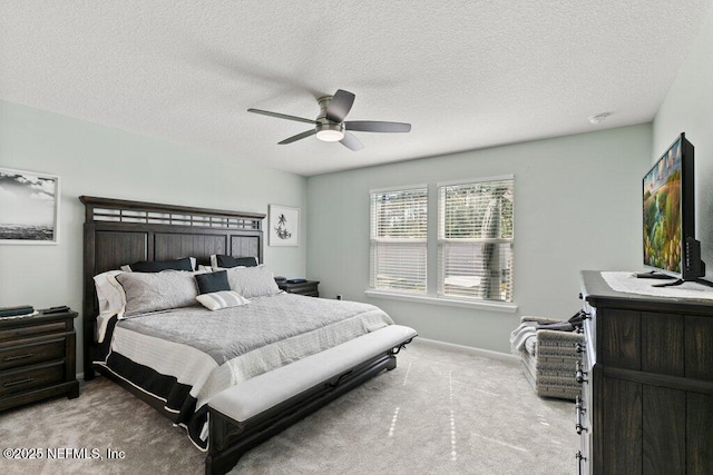 carpeted bedroom featuring a ceiling fan, baseboards, and a textured ceiling