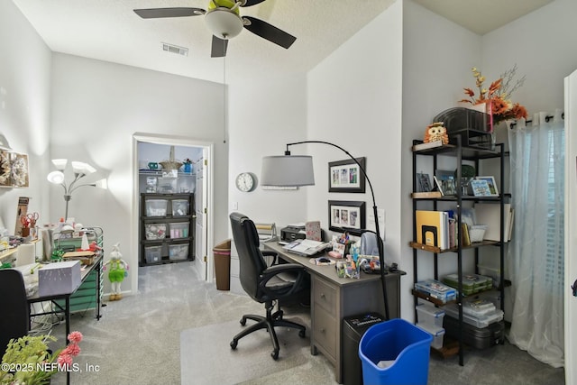 office space with visible vents, light carpet, and ceiling fan