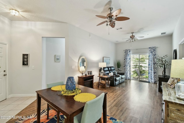 dining area with visible vents, baseboards, light wood-style floors, and a ceiling fan