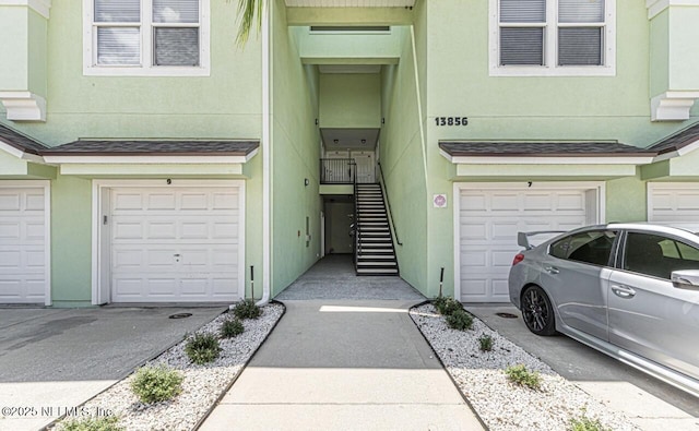 exterior space with a garage, driveway, and stucco siding