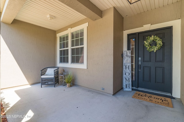 entrance to property with a patio area and stucco siding