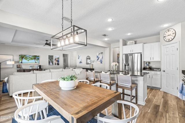 dining area featuring visible vents, a ceiling fan, a textured ceiling, recessed lighting, and light wood-style floors