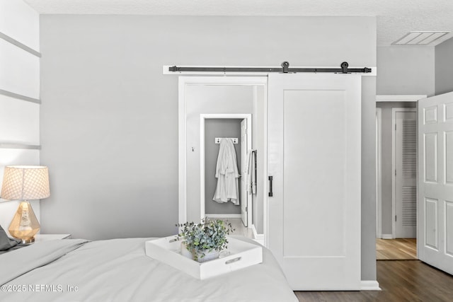 bedroom featuring visible vents, dark wood-style flooring, and a textured ceiling