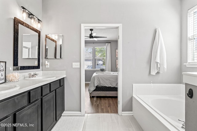 bathroom featuring a garden tub, a sink, ensuite bath, double vanity, and ceiling fan