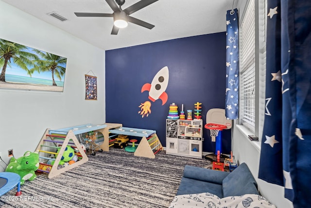 recreation room featuring carpet flooring, visible vents, and ceiling fan