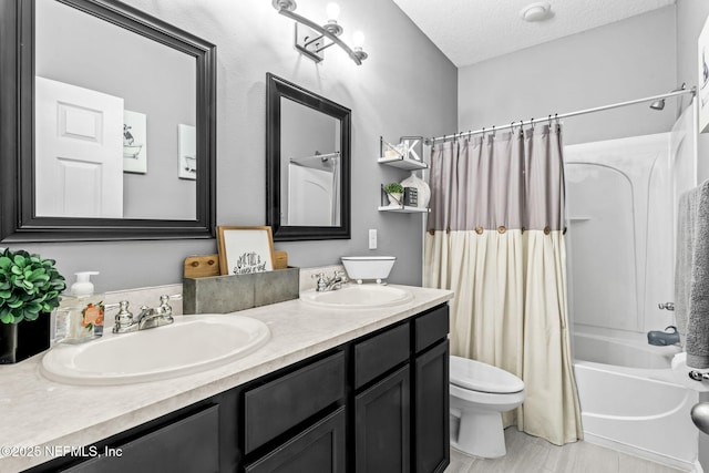 full bath featuring a textured ceiling, toilet, shower / bathtub combination with curtain, and a sink