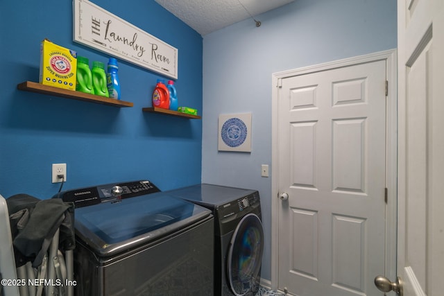 clothes washing area featuring washer and clothes dryer, laundry area, and a textured ceiling