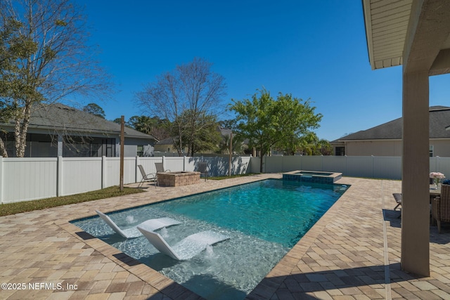 view of pool featuring an outdoor fire pit, a pool with connected hot tub, a fenced backyard, and a patio area