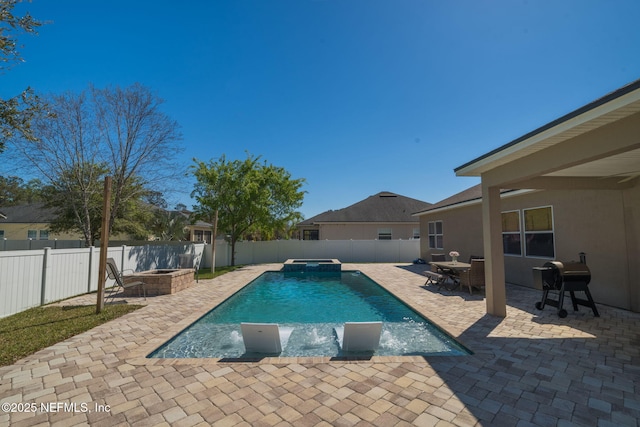 view of swimming pool with a fenced backyard, area for grilling, a pool with connected hot tub, and a patio