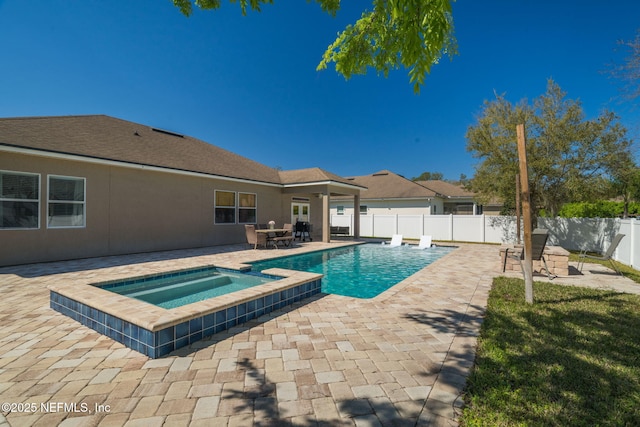 view of pool with a fenced backyard, a pool with connected hot tub, and a patio