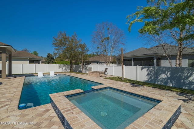 view of pool with a patio area, a pool with connected hot tub, and a fenced backyard