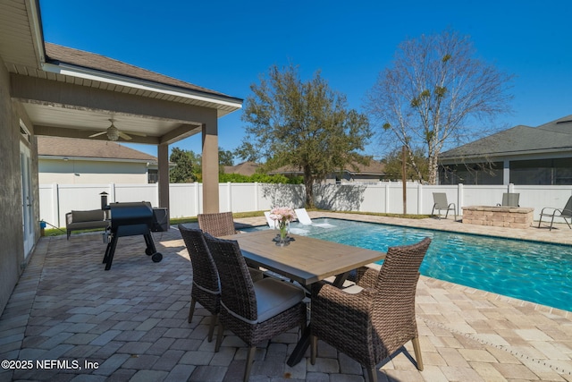 view of swimming pool featuring outdoor dining space, a patio, a fenced in pool, a fenced backyard, and ceiling fan