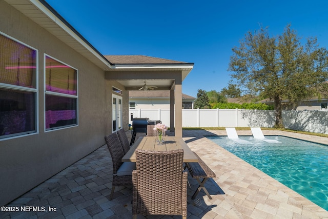 view of patio / terrace with ceiling fan, a fenced in pool, a fenced backyard, and outdoor dining space