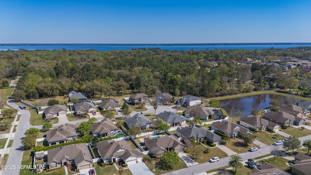 birds eye view of property with a residential view, a water view, and a view of trees