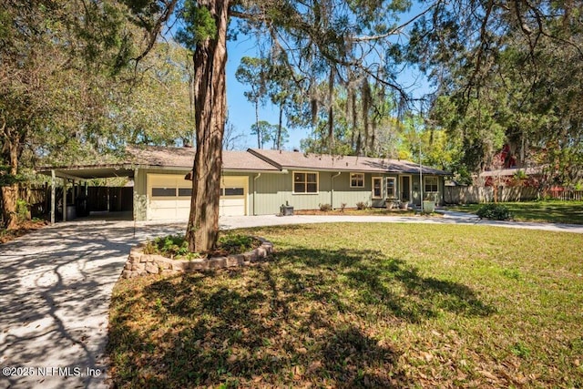 ranch-style house with an attached carport, a front lawn, fence, concrete driveway, and an attached garage