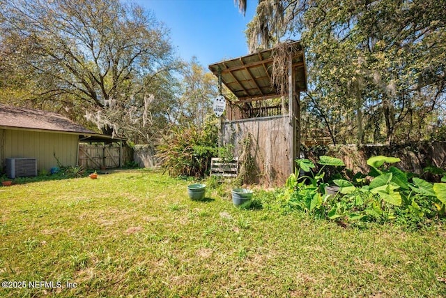 view of yard with central air condition unit and fence