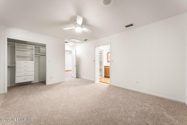 unfurnished bedroom featuring visible vents, baseboards, ensuite bath, a closet, and light colored carpet