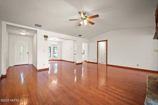 unfurnished living room featuring visible vents, ceiling fan with notable chandelier, a textured ceiling, wood finished floors, and vaulted ceiling