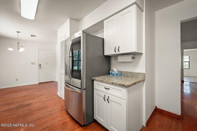 kitchen with visible vents, light wood-style flooring, white cabinets, smart refrigerator, and a notable chandelier