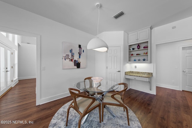 dining area featuring dark wood-style flooring, baseboards, and visible vents
