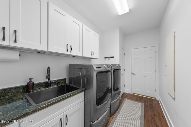 laundry room featuring a sink, washer and dryer, baseboards, dark wood-style floors, and cabinet space