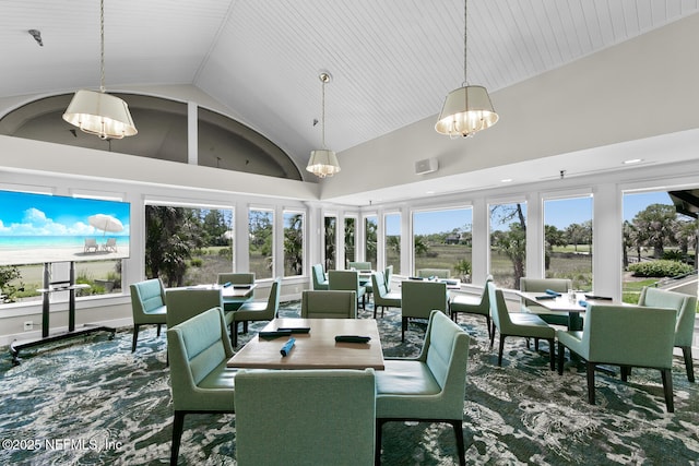 dining area featuring a chandelier, vaulted ceiling, and a water view