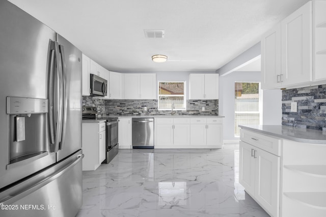 kitchen featuring white cabinetry, open shelves, marble finish floor, and stainless steel appliances