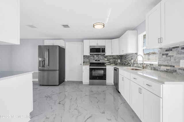 kitchen featuring visible vents, decorative backsplash, appliances with stainless steel finishes, marble finish floor, and a sink