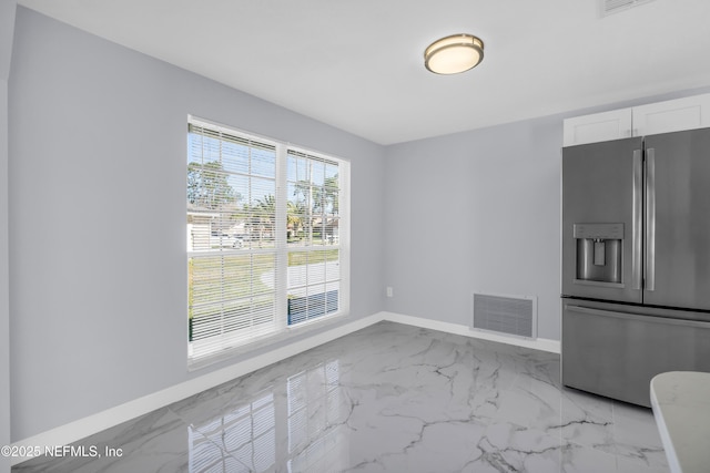 unfurnished dining area featuring visible vents, baseboards, and marble finish floor