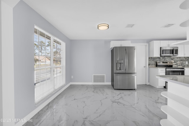 kitchen featuring visible vents, marble finish floor, backsplash, and appliances with stainless steel finishes