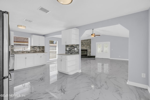 kitchen with visible vents, a ceiling fan, open shelves, tasteful backsplash, and freestanding refrigerator