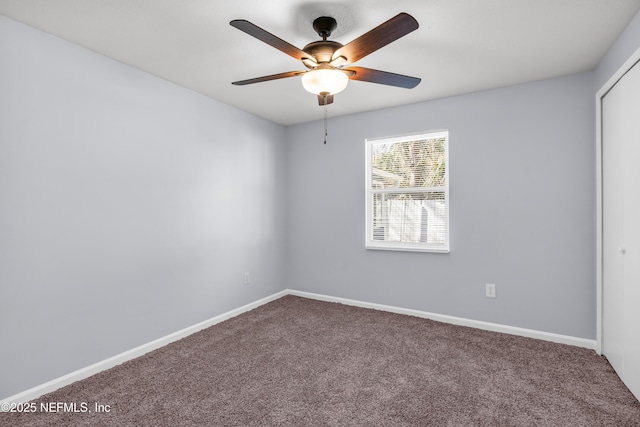 carpeted empty room with a ceiling fan and baseboards