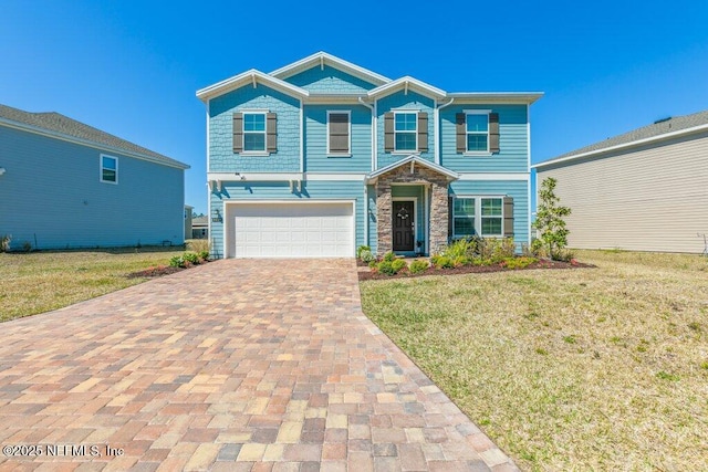 view of front of home featuring stone siding, an attached garage, decorative driveway, and a front lawn