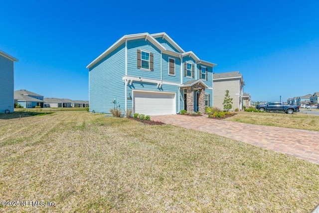 view of front of property with stone siding, driveway, a front lawn, and an attached garage