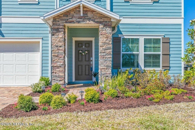 doorway to property with stone siding and a garage