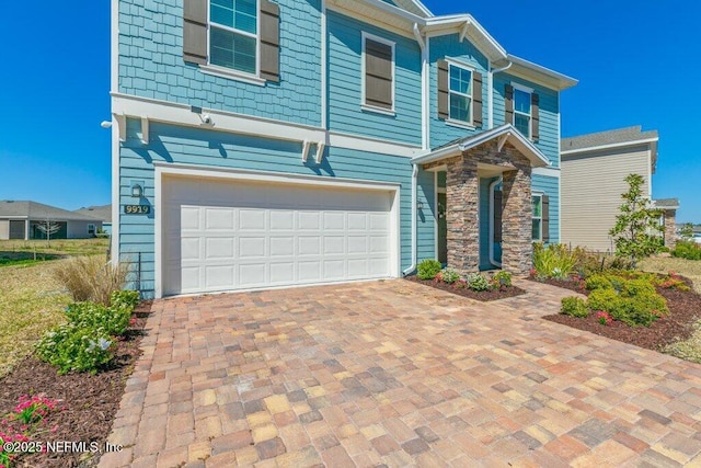 view of front of property with a garage, stone siding, and driveway