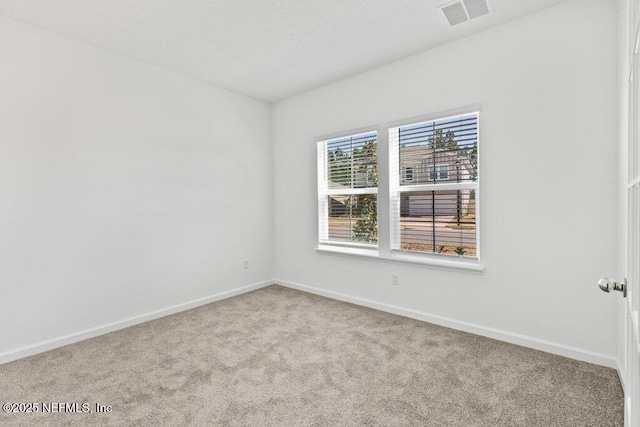 unfurnished room with visible vents, baseboards, and carpet floors