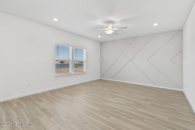 empty room with light wood finished floors, recessed lighting, baseboards, and a ceiling fan