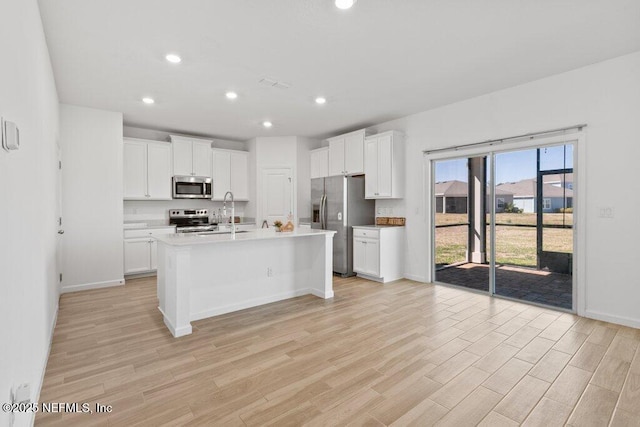 kitchen featuring white cabinets, light wood-type flooring, and appliances with stainless steel finishes