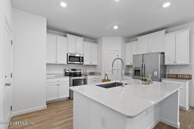 kitchen featuring a sink, light wood-type flooring, appliances with stainless steel finishes, and white cabinetry