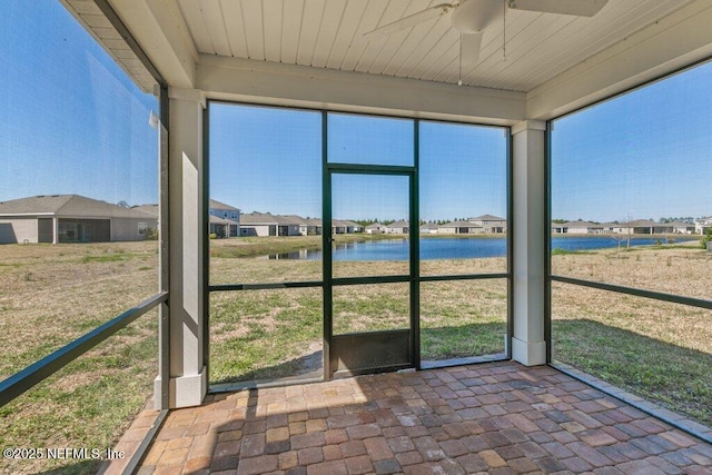 unfurnished sunroom featuring wood ceiling, ceiling fan, and a water view