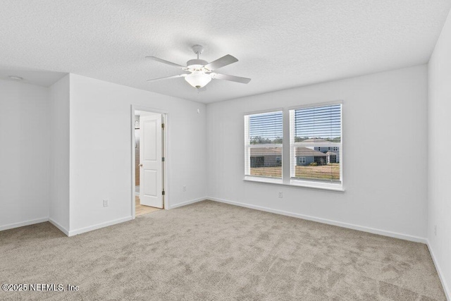 unfurnished room featuring baseboards, a textured ceiling, a ceiling fan, and carpet floors