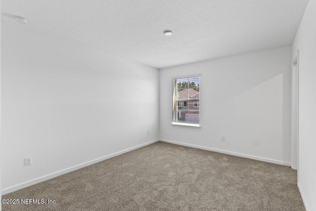 unfurnished room featuring carpet flooring, a textured ceiling, and baseboards