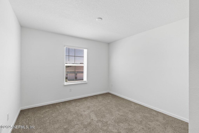 empty room with baseboards, a textured ceiling, and carpet