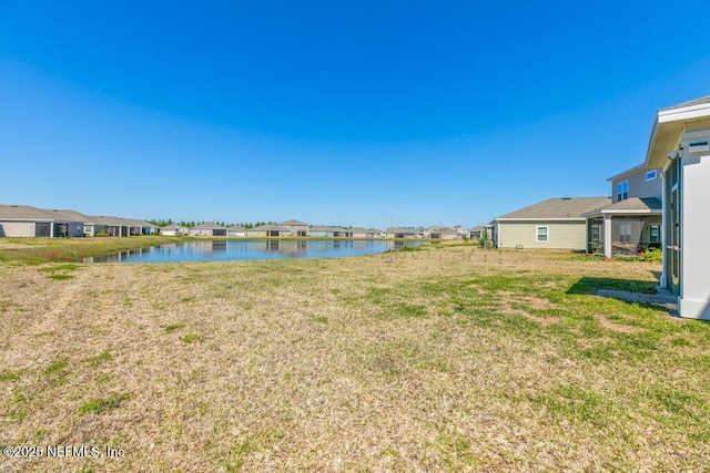 view of yard featuring a residential view and a water view