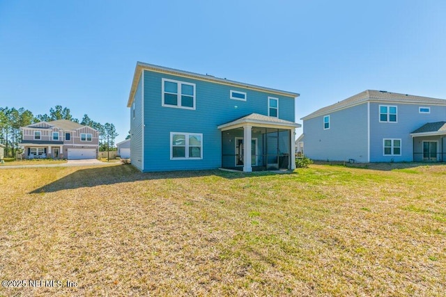 back of property featuring a lawn and a sunroom