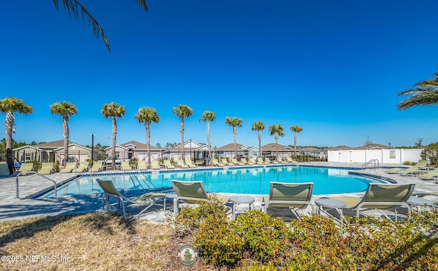 community pool featuring a patio area, a residential view, and fence